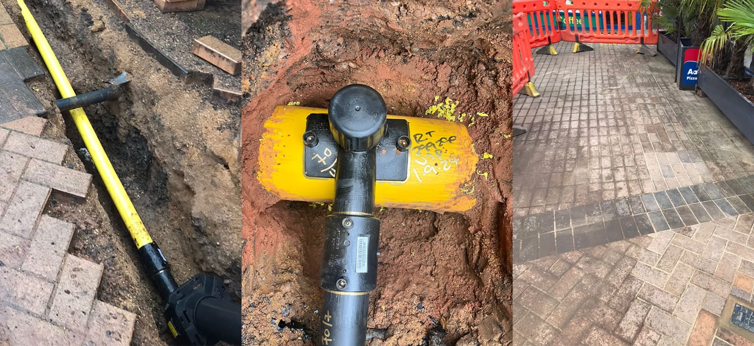 USP team installing gas mains in an open trench with safety barriers on a live development site